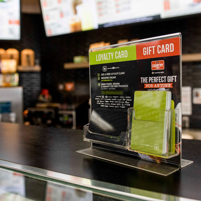 Loyalty and gift card display at Country Style café, promoting customer rewards and gift options in a modern coffee shop setting.