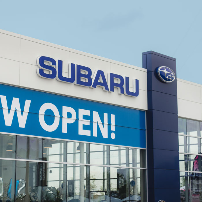 Subaru dealership exterior with "NOW OPEN!" sign, showcasing new branding by C17media.