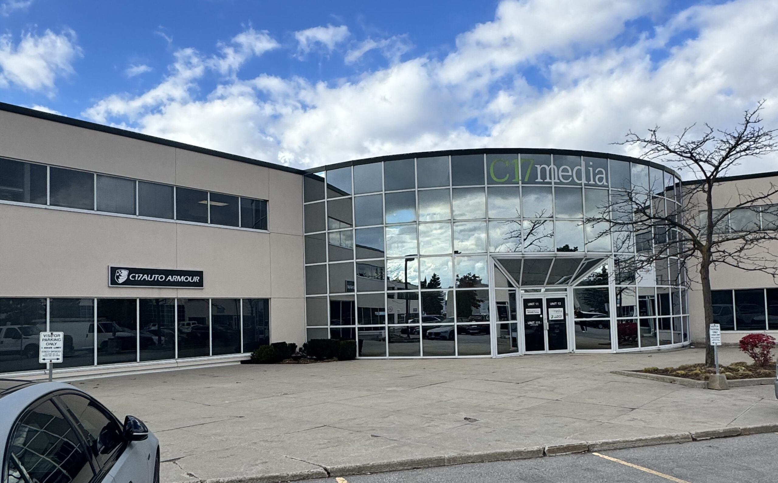 C17media building exterior featuring large glass windows, C17AUTO ARMOUR sign, and clear blue sky, representing innovative print and visual communication services.